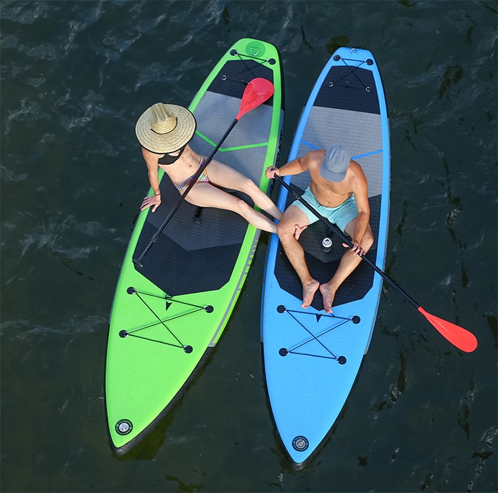 two people sitting on stand up paddle boards from a top overhead view